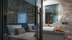 A modern bathroom with a glass-enclosed shower, a large mirror, and a vanity with toiletries. - Beach front home in Privlaka (Privlaka)