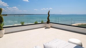 A terrace with a view of the sea, a potted plant, and white outdoor furniture. - Beach front home in Privlaka (Privlaka)