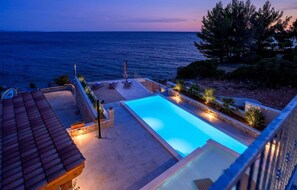 A swimming pool with a view of the sea at dusk. - 3 bedroom stunning home in Ivan Dolac (Ivan Dolac)