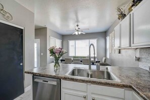 A kitchen with granite countertops, stainless steel appliances, and white cabinetry. - Sandstone Bliss - 3 bed, 2.5 Bath Cozy Home! (Mesa)