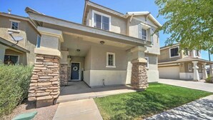 A two-story house with a stone facade, a front porch, and a well-maintained lawn. - Sandstone Bliss - 3 bed, 2.5 Bath Cozy Home! (Mesa)