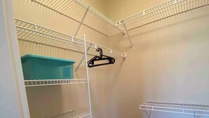 A walk-in closet with multiple wire shelves, a blue storage bin, and a hanging rack. - A comfortable two-bedroom with even a king size bed , close to YVR Richmond (Richmond)
