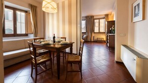 Un comedor con una mesa de madera, sillas y una lámpara colgante.