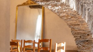 A rustic interior with stone walls, a wooden ceiling, and a brown leather sofa.