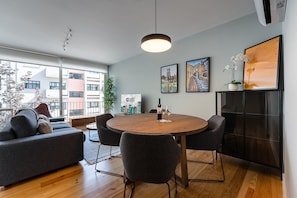 Relax in this stylish living room with a round dining table and city views.