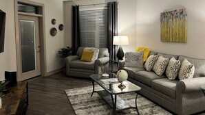A modern living room with a sofa, armchair, coffee table, and a globe. - 5840 #312 Cozy but Accessible Hideaway. Lots of Amenities (Chapel Hill)
