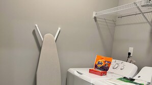 A laundry area with a washing machine, an iron, and a basket. - 5840 #312 Cozy but Accessible Hideaway. Lots of Amenities (Chapel Hill)