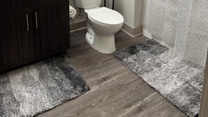 A bathroom with a toilet, sink, and shower curtain. - 5840 #312 Cozy but Accessible Hideaway. Lots of Amenities (Chapel Hill)