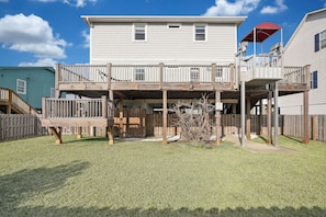 A two-story house with a wooden deck and a red umbrella. - Entire 5 Bed Room Beach House  (Carolina Beach)