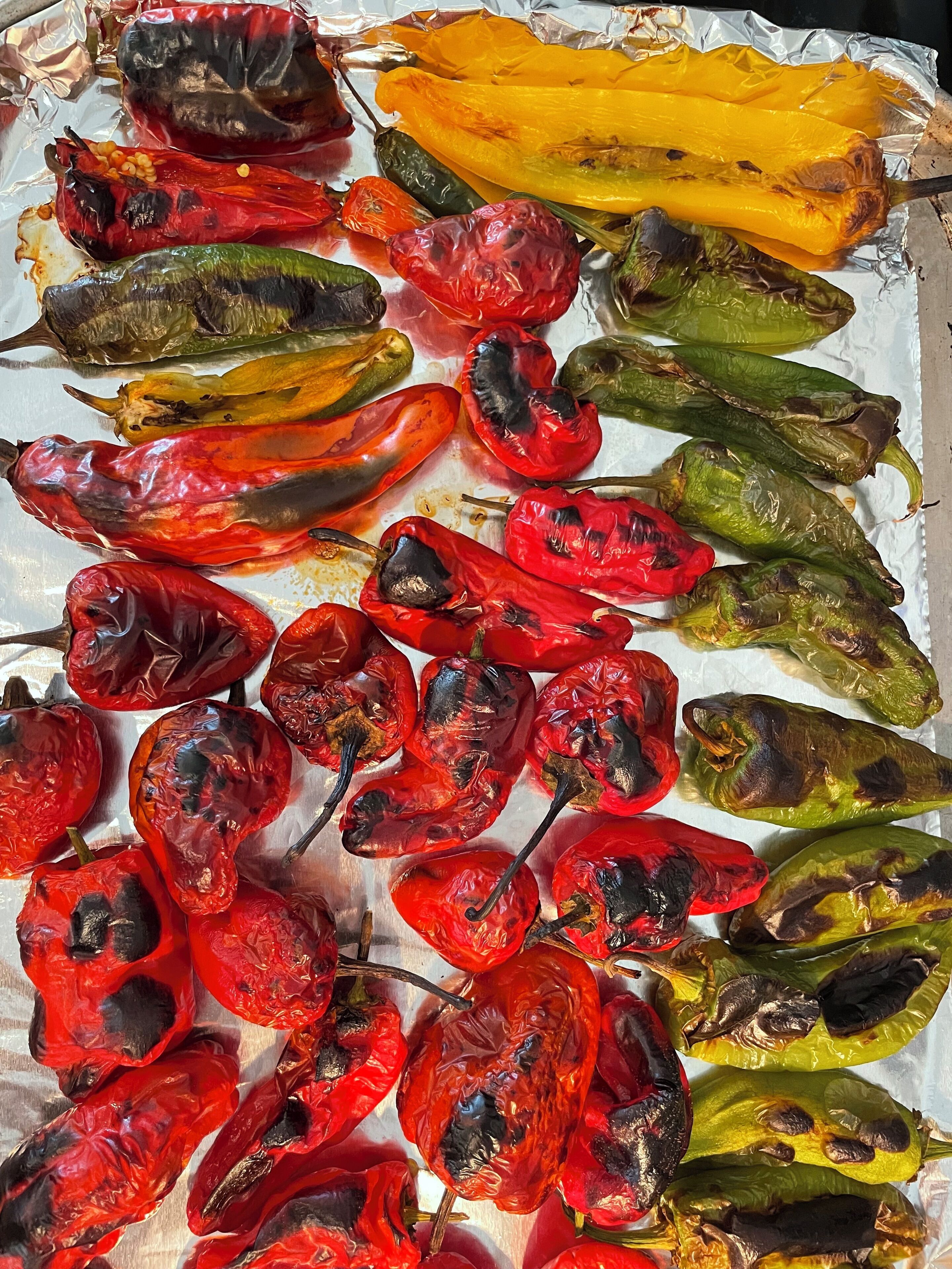 A variety of roasted peppers on a tray.