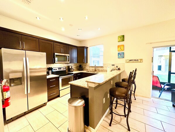 Enjoy cooking in this well-equipped kitchen with a central island, sink, and appliances.