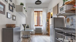 A compact kitchen with a dining area, a built-in stove, and a radiator.