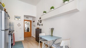 A compact kitchen with a refrigerator, stove, and a dining area with a table and chairs.