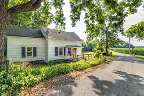 A white house with a porch, surrounded by greenery and a gravel driveway. - Peaceful Franklin Cottage ~ 1 Mi to Downtown! (Franklin)