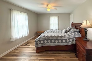 A bedroom with a bed, a ceiling fan, a nightstand, and a lamp. - Peaceful Franklin Cottage ~ 1 Mi to Downtown! (Franklin)