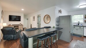 A modern kitchen with a central island, built-in appliances, and a dining area with a sofa and chairs.