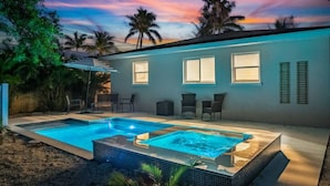 A two-story house with a swimming pool and outdoor seating area. - 200 steps to the Beach | Heated pool + spa (Holmes Beach)