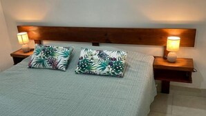 A bed with a wooden headboard, two matching pillows with a tropical leaf pattern, and two bedside lamps on wooden nightstands. - Villa 1 minute walking to beach with pool A/C pet friendly (Jaco)