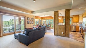 A spacious living area with a gray sofa, a dining table, and a kitchen in the background. - Family Friendly w/ Suncadia Pool Access (Cle Elum)