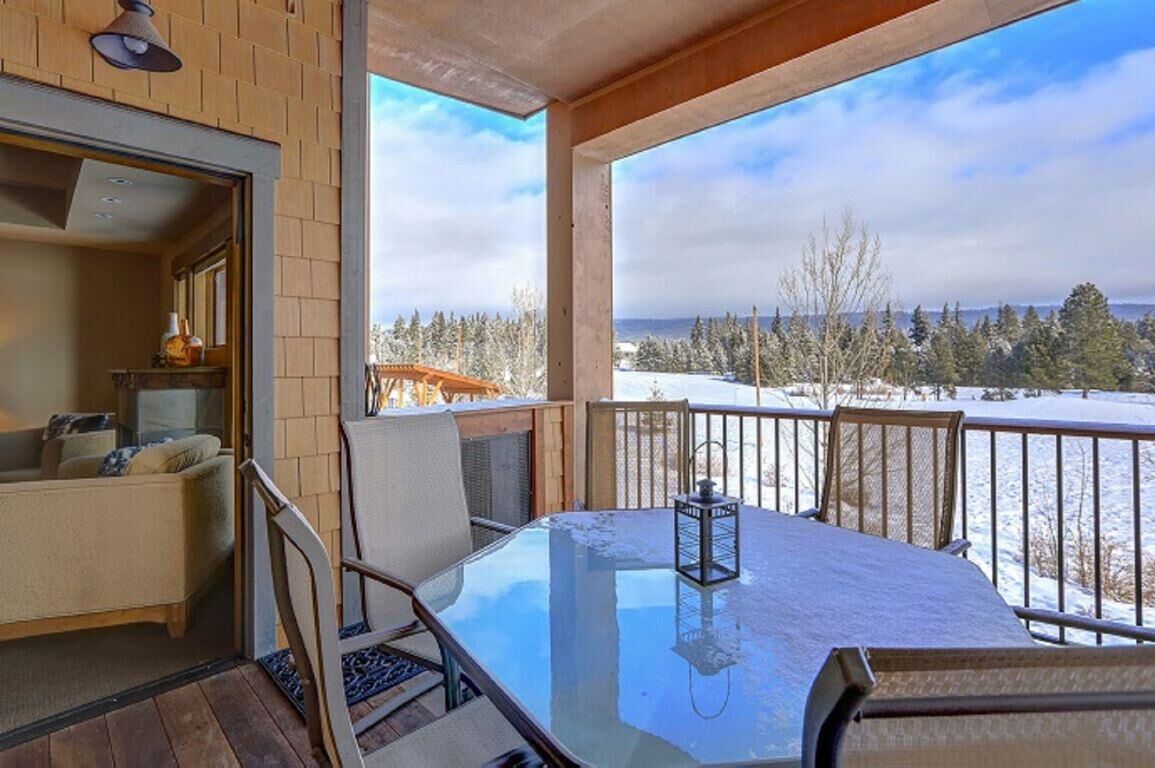 Un balcon accueillant avec une table en verre, des chaises et une lanterne.