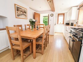 A spacious kitchen with wooden cabinets, a large stove, and a dining area with a wooden table and chairs.