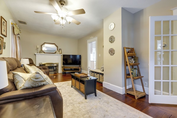 A living room with a sofa, coffee table, TV, fireplace, and decorative items. - 3 Mi to Dtwn Springfield: Winter Retreat w/ Office (Springfield)