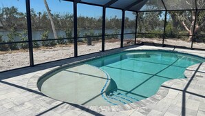 Una piscina con vistas despejadas del paisaje circundante, incluyendo árboles y una extensión de agua.