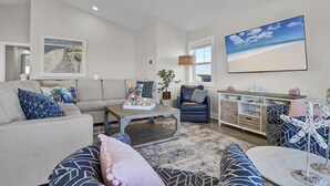 Ein Wohnzimmer mit Sofa, Couchtisch, Fernseher und Schrank.