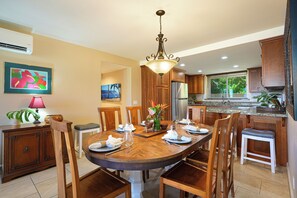 Enjoy meals in this spacious dining area with a large table and comfortable chairs, complemented by a modern kitchen.