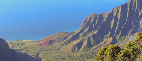 A mountainous landscape with a clear view of the ocean.