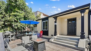 An outdoor patio with a fire pit table, chairs, and a blue umbrella. - Riviera Bay View Dream - Private Patio with Bay View, Parking & W/D! (San Diego)