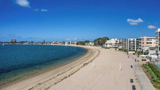 A beach with a clear blue sky, a sandy shore, and buildings in the background. - Riviera Bay View Dream - Private Patio with Bay View, Parking & W/D! (San Diego)