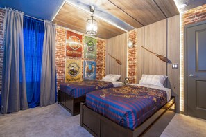 Ein Schlafzimmer mit zwei Betten, einer Ziegelwand und Postern von Harry-Potter-Figuren.