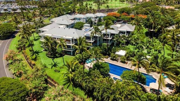 A resort with a pool, multiple buildings, and lush greenery.