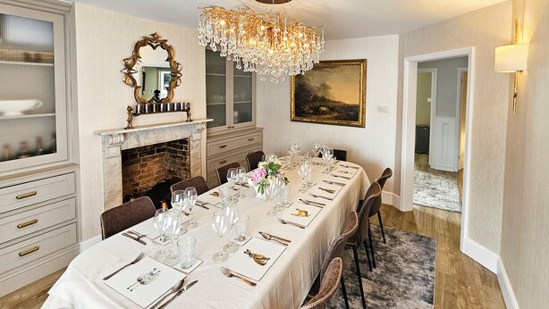 A formal dining room with a long table set for a meal, a fireplace, and a chandelier. - Landguard - Yarmouth, Isle of Wight (Isle of Wight)