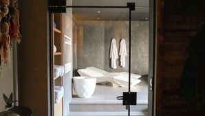 A modern bathroom with a glass door, a sink, and two white towels hanging on the wall. - Chalet Kusi Wasi is a luxury home in the heart of the pyrénées mountains  (Font-Romeu-Odeillo-Via)