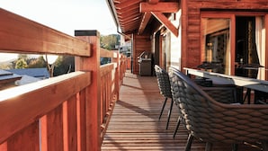 A wooden deck with a table and chairs, overlooking a mountainous landscape. - Chalet Kusi Wasi is a luxury home in the heart of the pyrénées mountains  (Font-Romeu-Odeillo-Via)