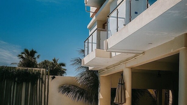 A modern building with a swimming pool, outdoor seating, and a covered area. - Casa Boutique Maria Bonita  (La Manzanilla)