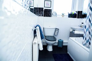 Un baño moderno con inodoro, bidé, lavabo y bañera.