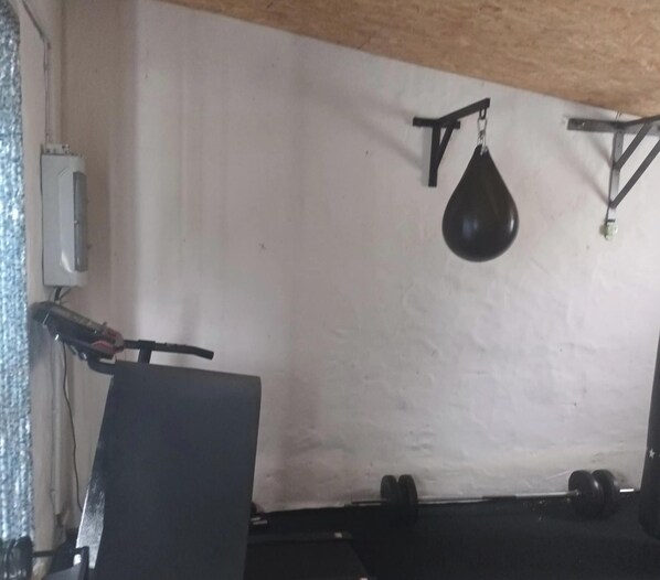 A room with a white wall, a punching bag, and a chair. - Apartment 'Haus Beim Schloß' with Private Terrace, Wi-Fi and Air Conditioning (Woldegk)