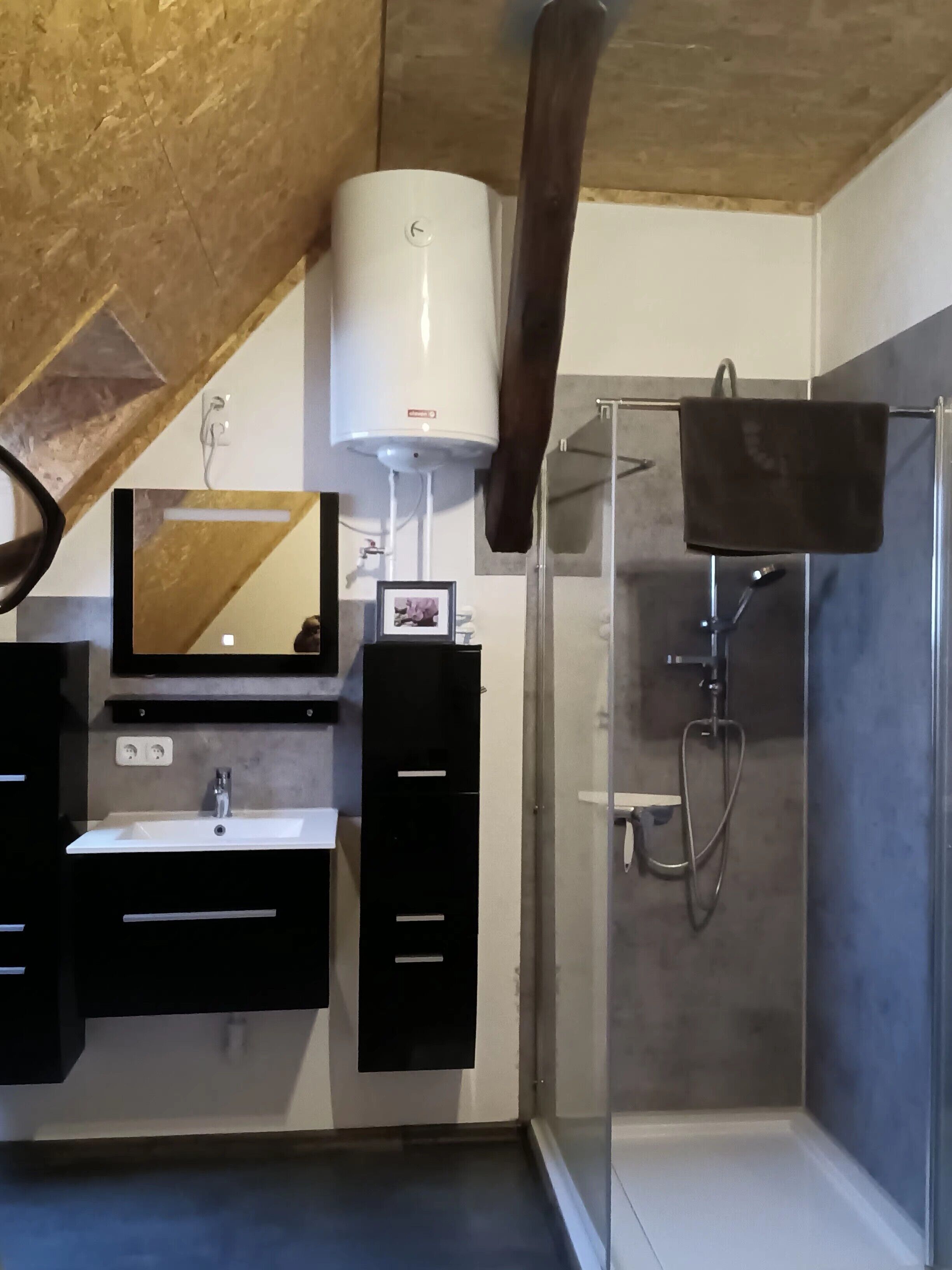 Ein modernes Badezimmer mit Dusche, Waschbecken und Spiegel.