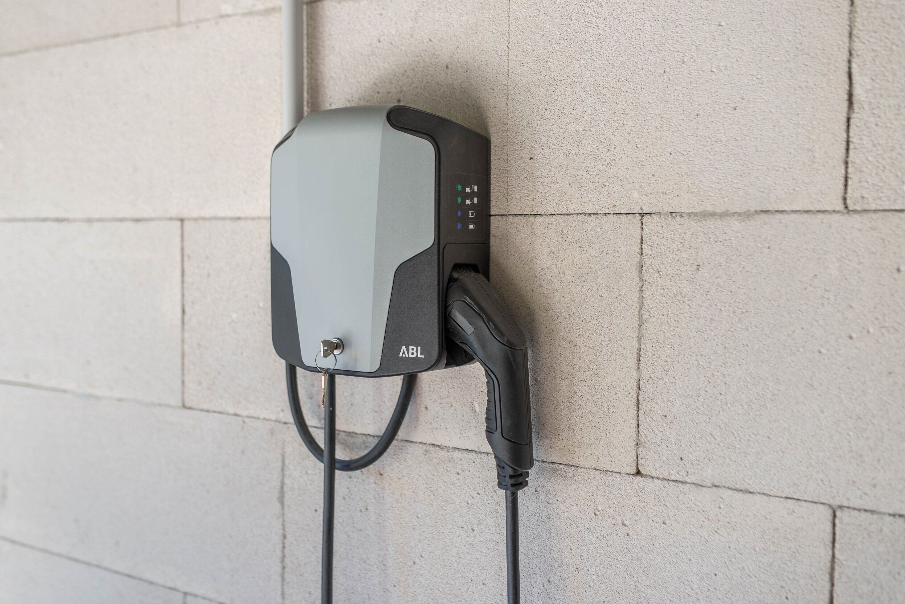 Una estación de carga montada en la pared, con un cable conectado.