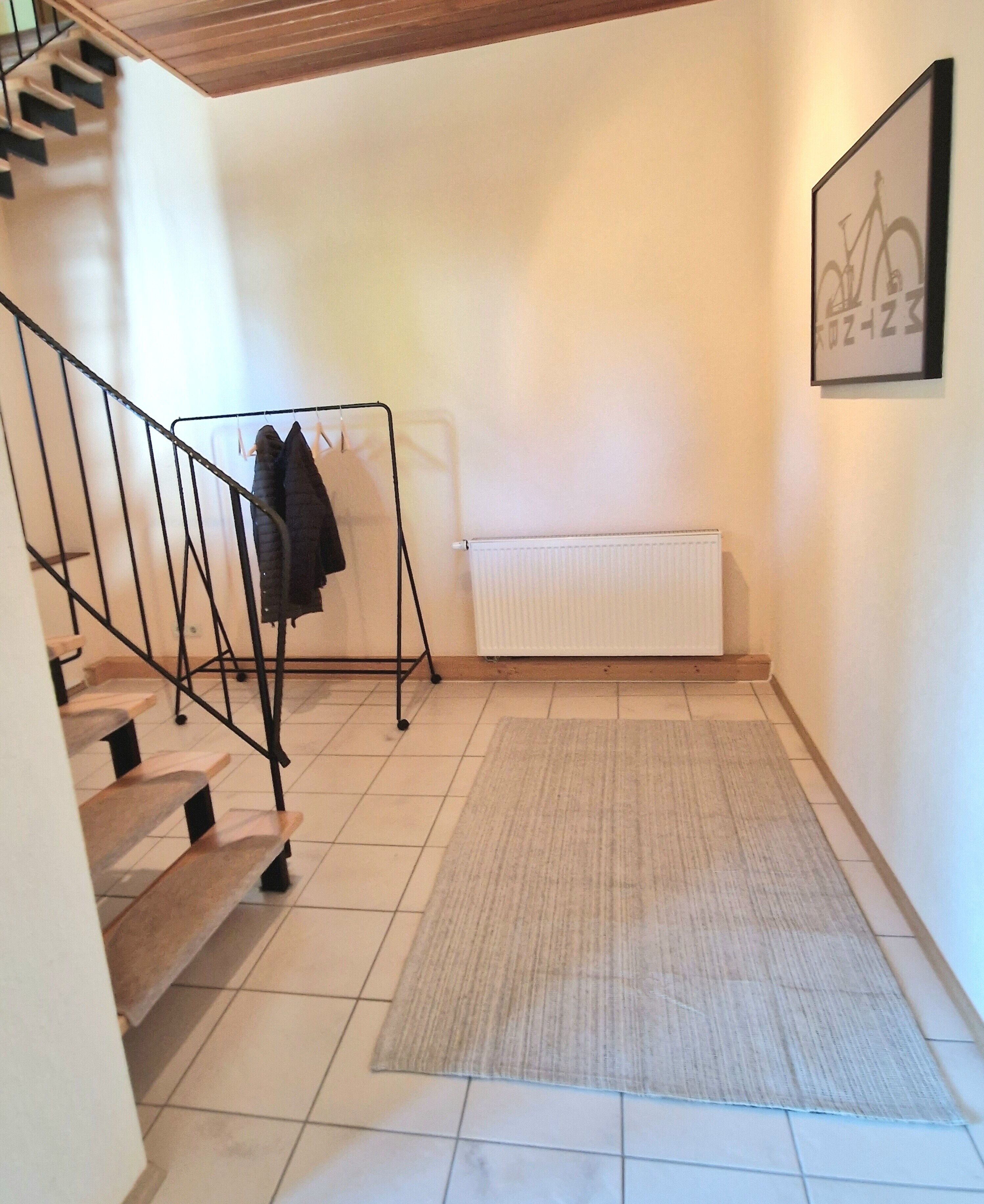 A staircase with a metal railing, a radiator, and a framed picture on the wall.