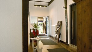 A hallway with a wooden door, a radiator, and a plant. - Apartment 'Ferienwohnung 1' with Shared Garden and Wi-Fi (Vöhrenbach)