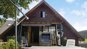 A wooden house with a porch, a small window, and a door. - Apartment 'Ferienwohnung 1' with Shared Garden and Wi-Fi (Vöhrenbach)