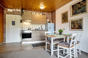 Eine Küche mit Holzausstattung, einem Kühlschrank und einem Esstisch mit Stühlen.