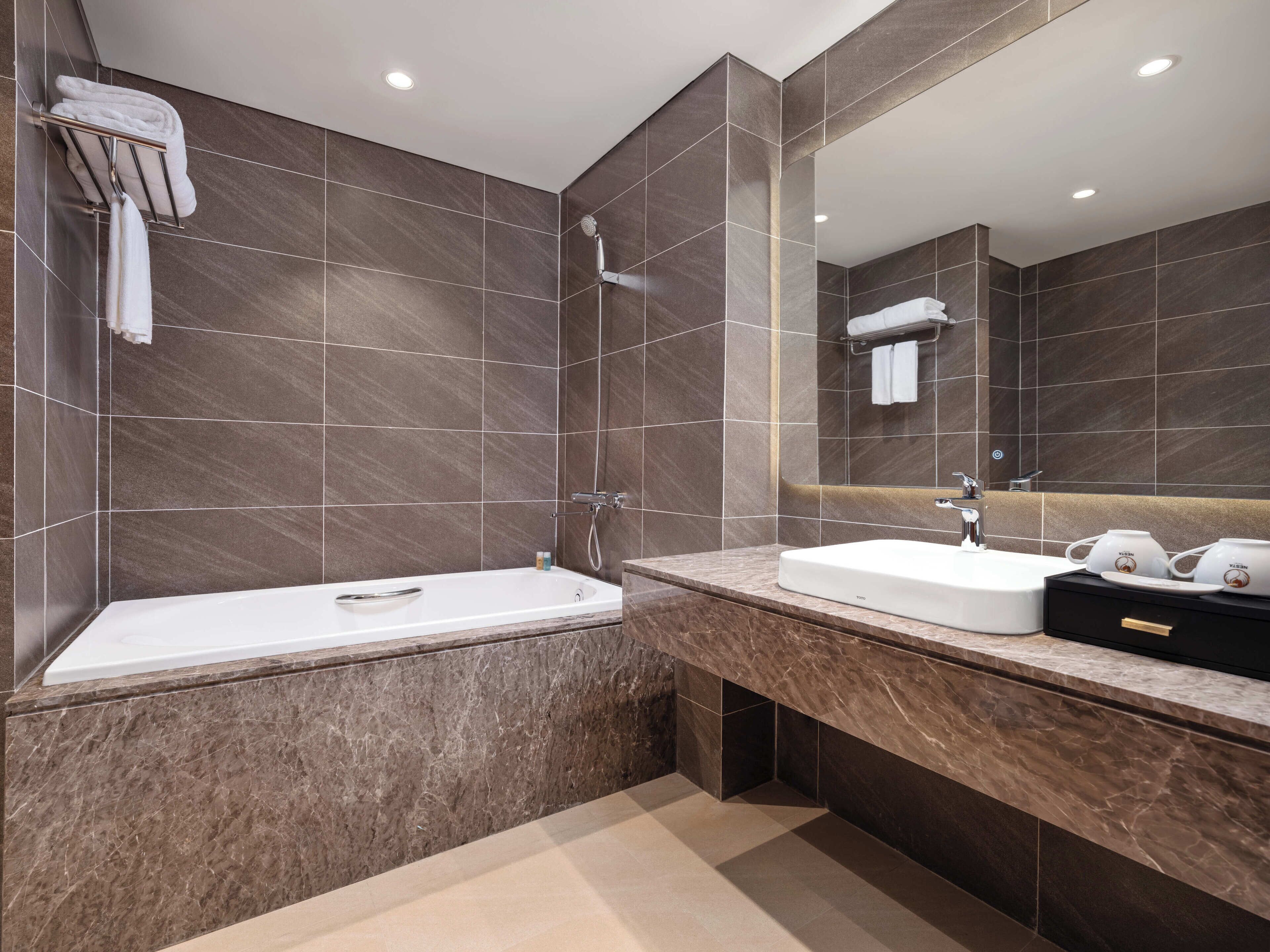 A modern bathroom with a bathtub, a sink, and a vanity.