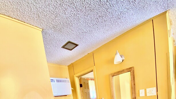 A bathroom with a white sink, a mirror, and a shower area. - Tropic Motel (Aransas Pass)