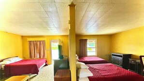 A room with two beds, a desk, a dresser, and a window with curtains. - Tropic Motel (Aransas Pass)