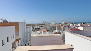 A rooftop view of a residential area with multiple buildings, some with visible water tanks and antennas. - Apartment Malva in Conil (Conil de la Frontera)